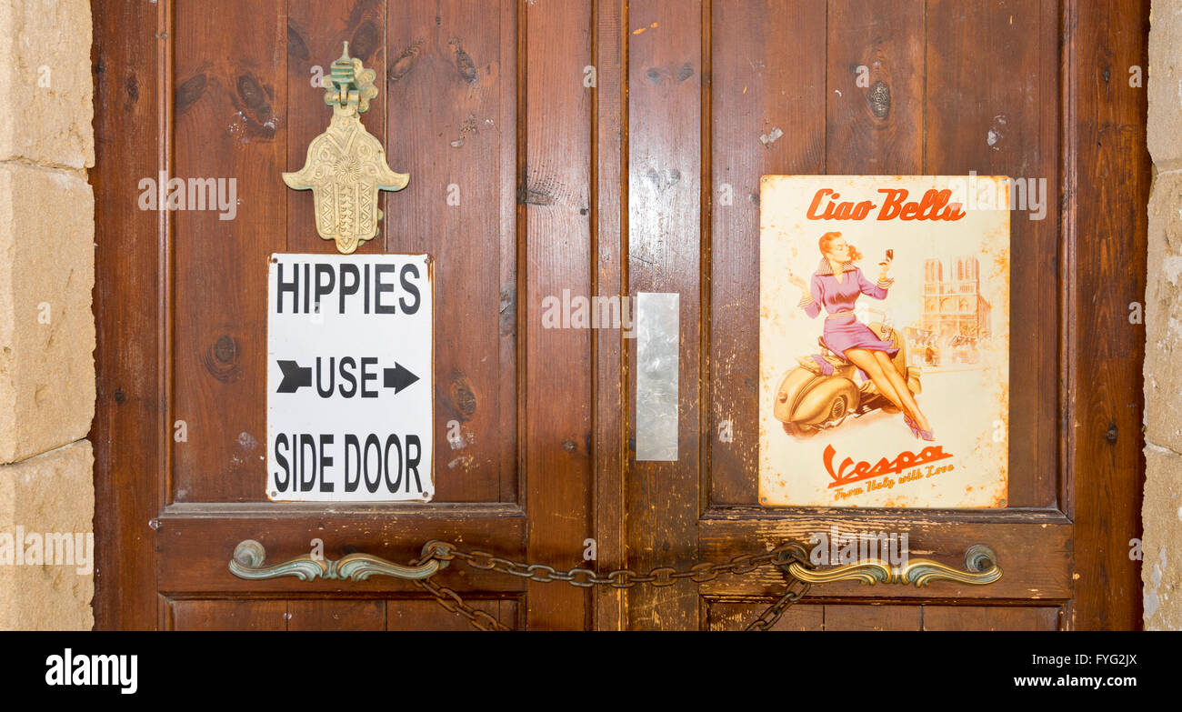 NORTH CYPRUS KYRENIA OLD TOWN WOODEN DOOR AND SIGNS HIPPIES AND VESPA Stock Photo