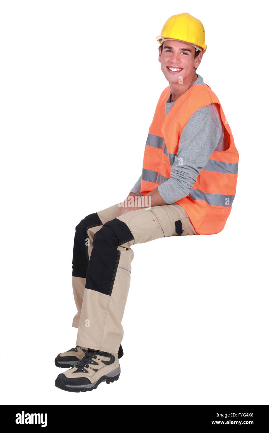 Young tradesman sitting on an invisible block Stock Photo