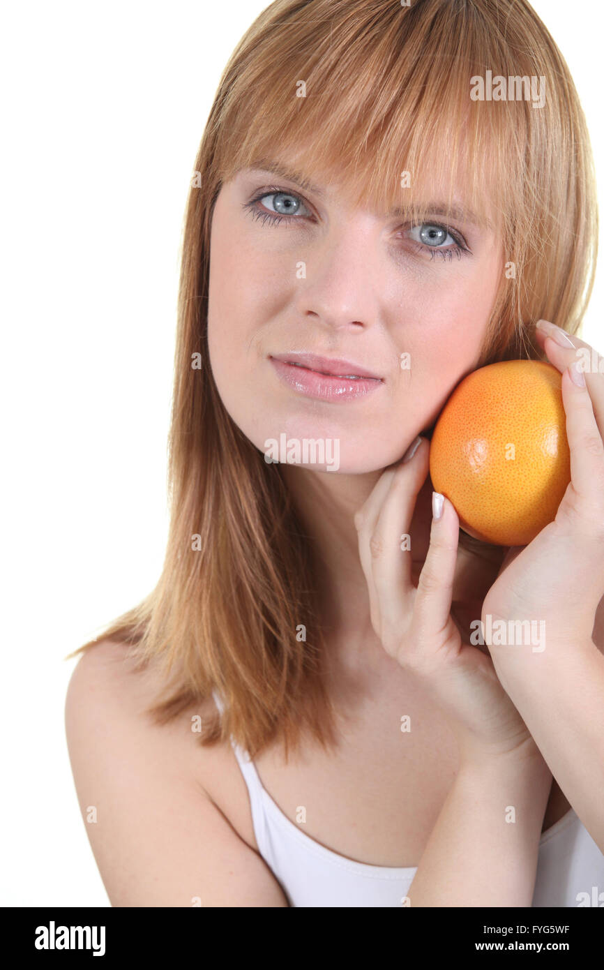 bust shot of red-haired girl posing with orange Stock Photo