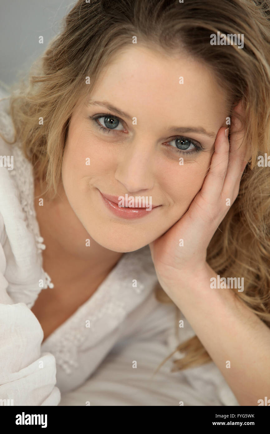Closeup of a natural blonde woman with her head in her hand Stock Photo