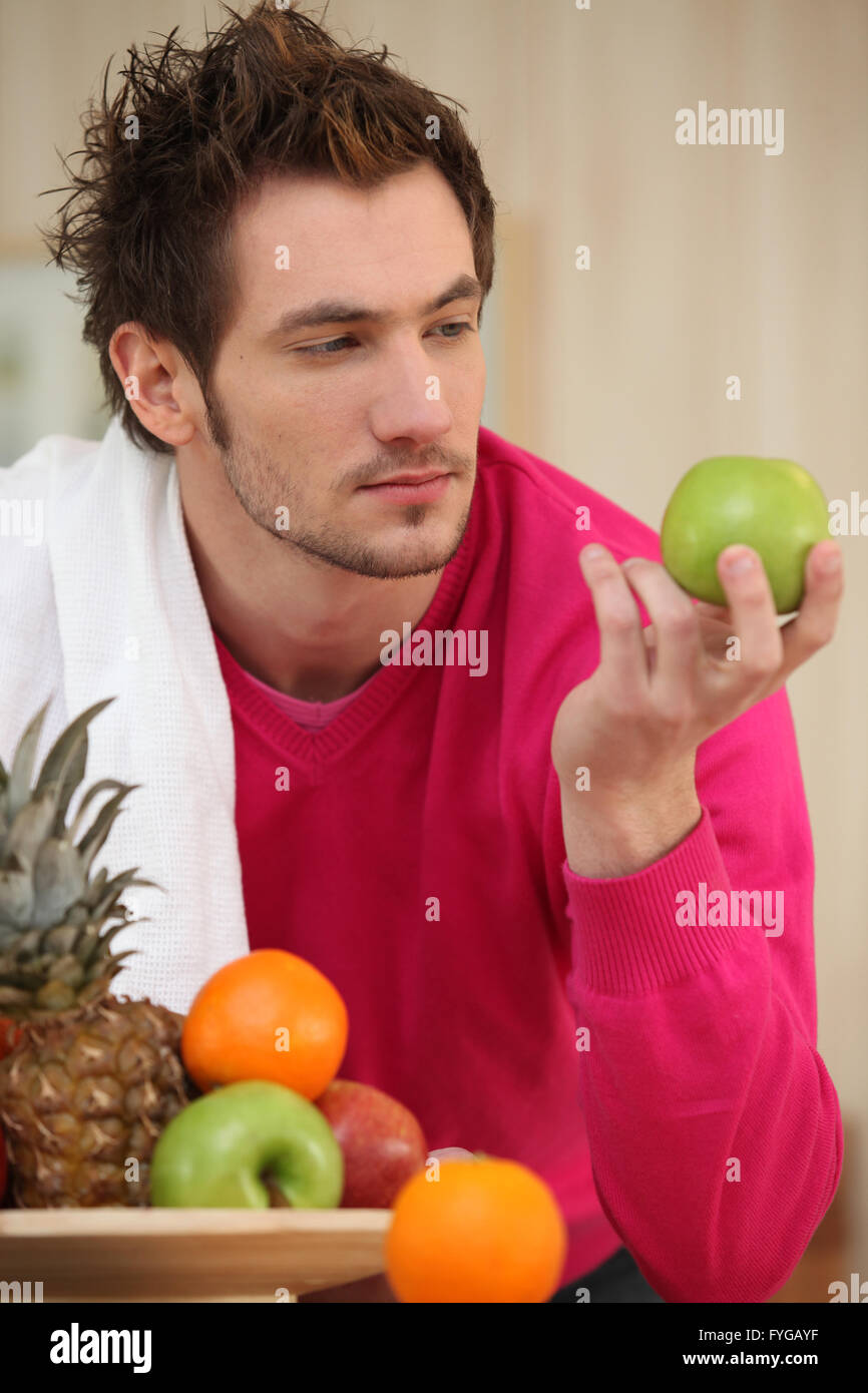 Young man picking an apple from a fruit bowl Stock Photo Alamy