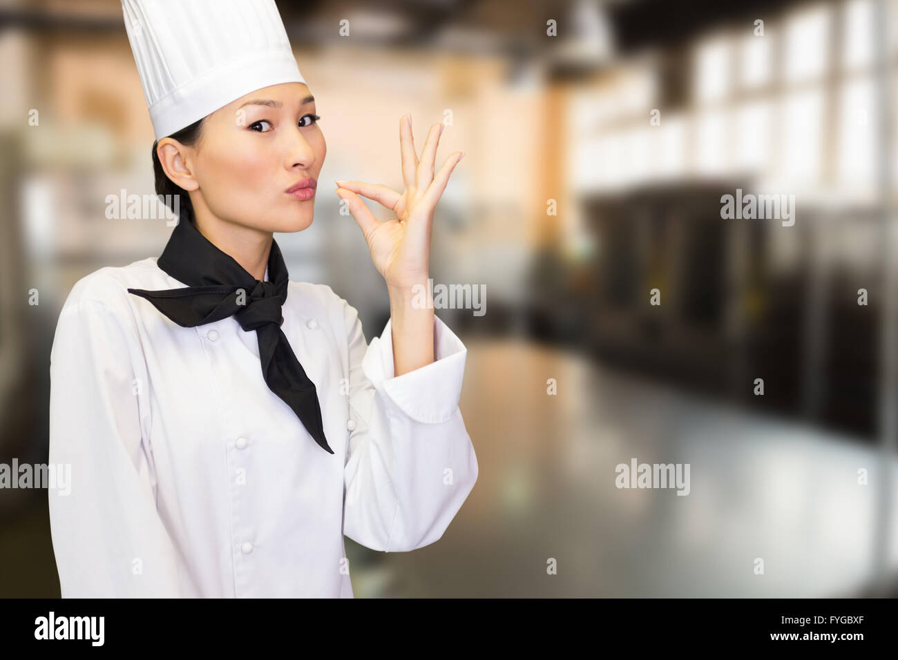 Composite image of smiling female cook in the kitchen Stock Photo