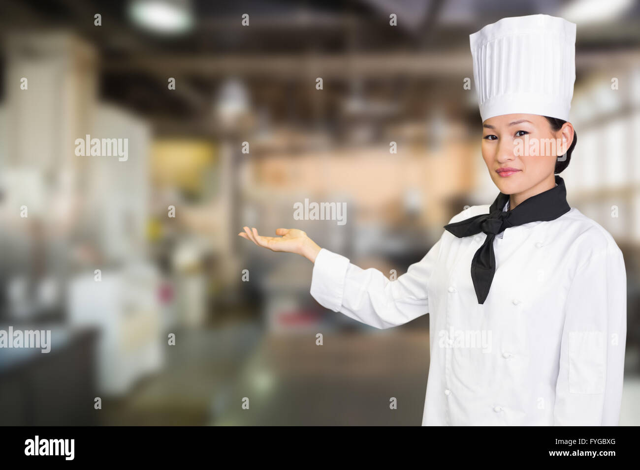 Composite image of confident female cook in the kitchen Stock Photo