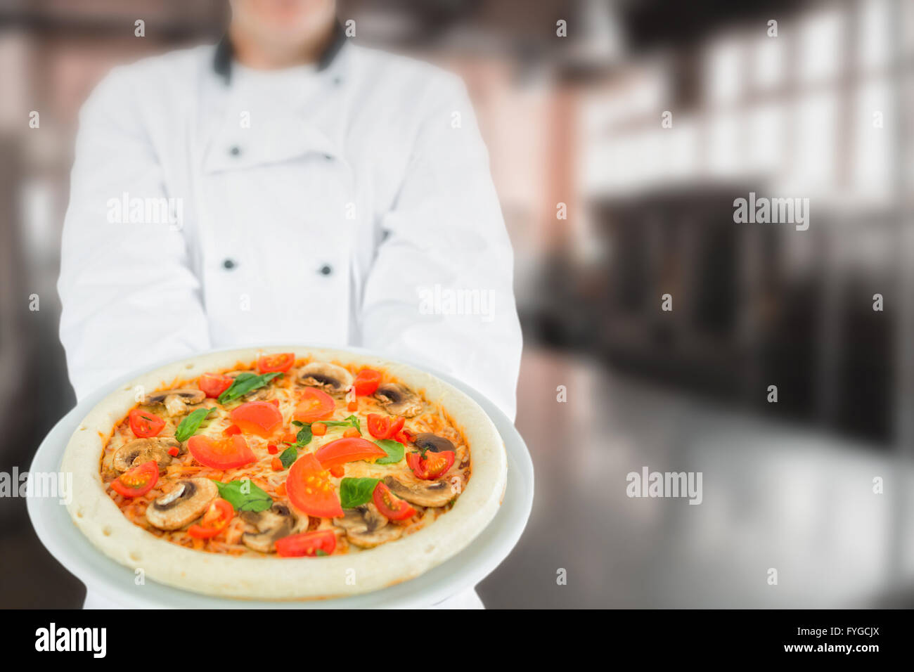 Composite image of chef holding delicious pizza Stock Photo