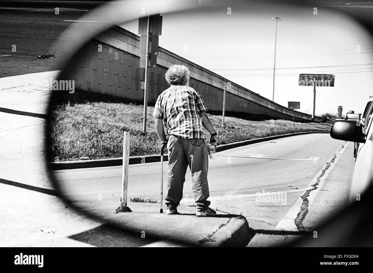 Picture from a mirror of a homeless man standing at an intersection ...