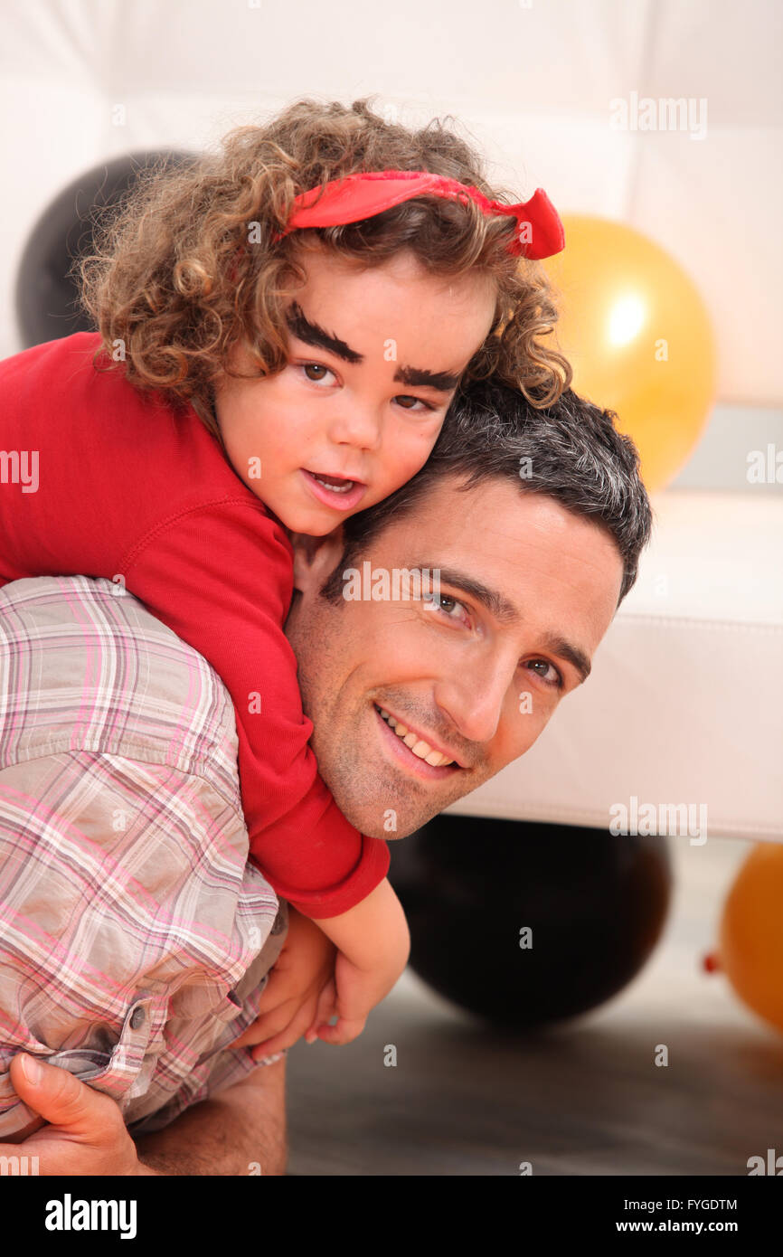 little girl on daddy's back celebrating Halloween Stock Photo