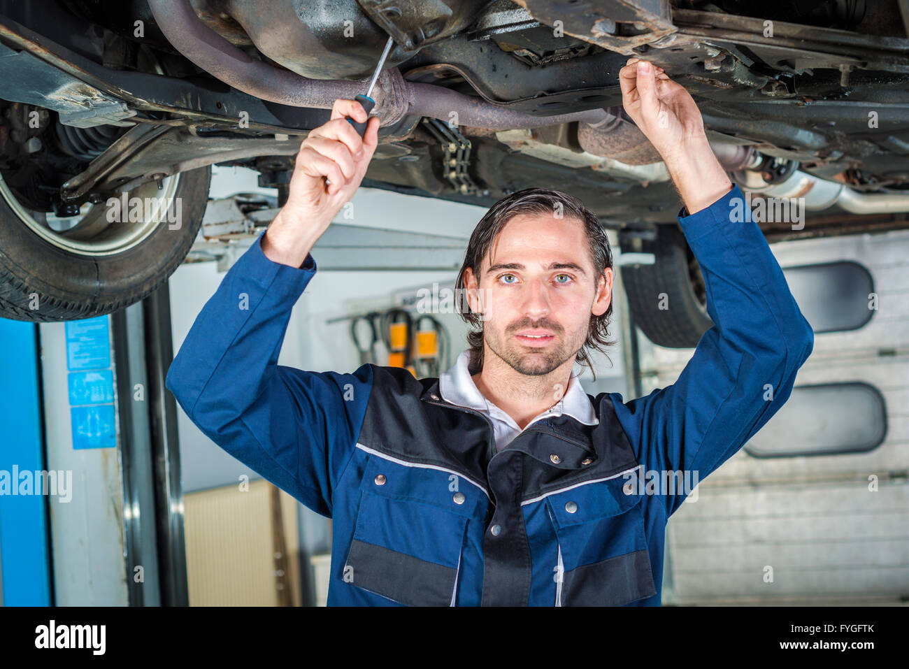 Mechanic checking the condition of a lifted car Stock Photo Alamy