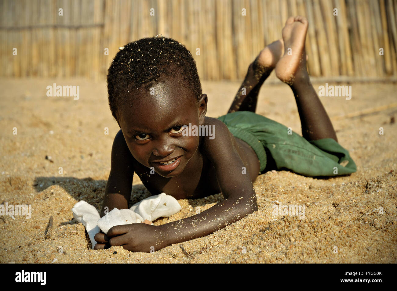 Bare boy lying on his belly on the beach in village of Chembe, Cape  Maclear, Malawi Stock Photo - Alamy