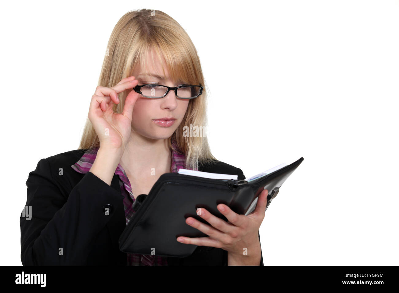 pretty blonde businesswoman consulting her agenda Stock Photo - Alamy