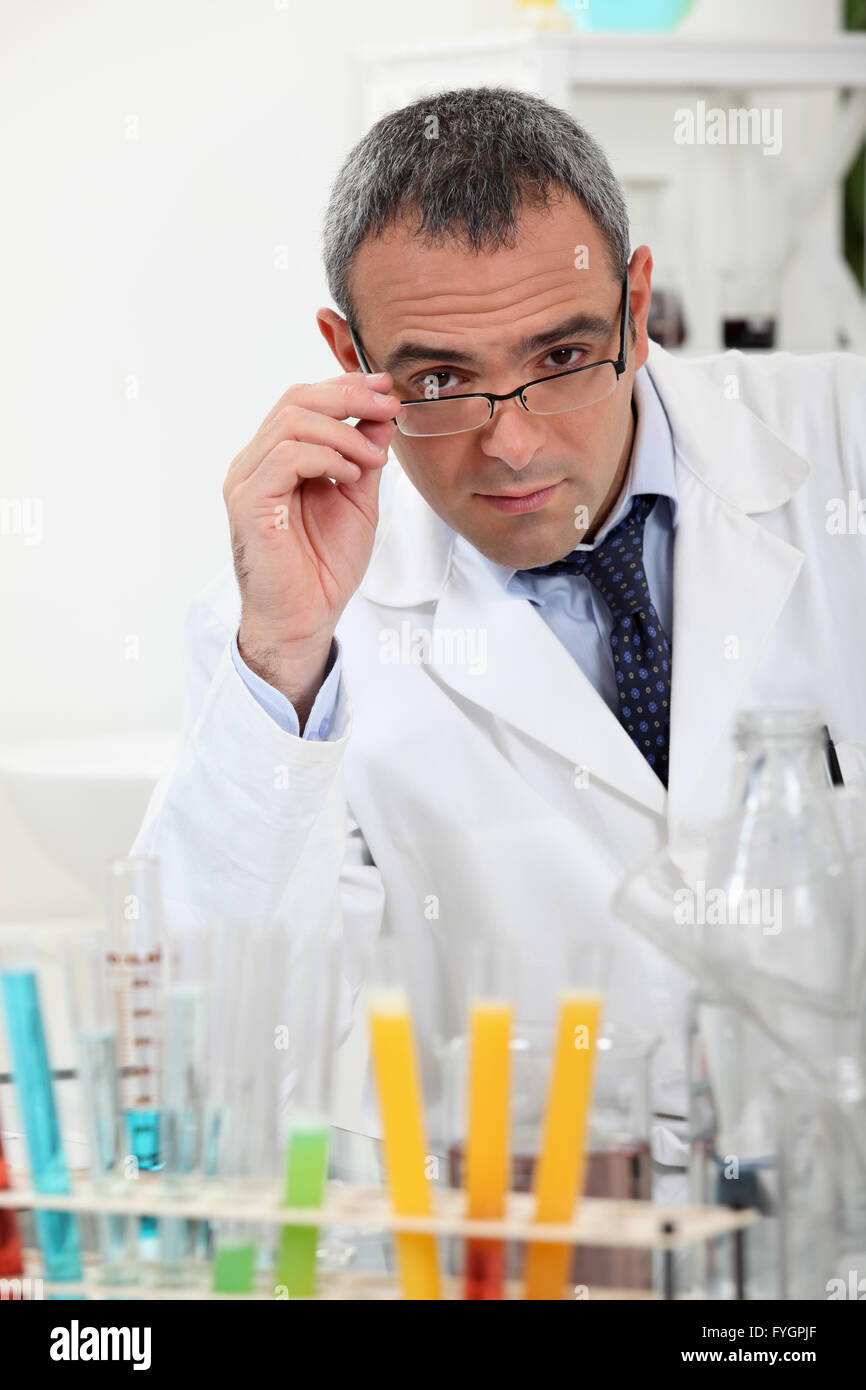 scientist touching his glasses behind test tubes in a laboratory Stock ...