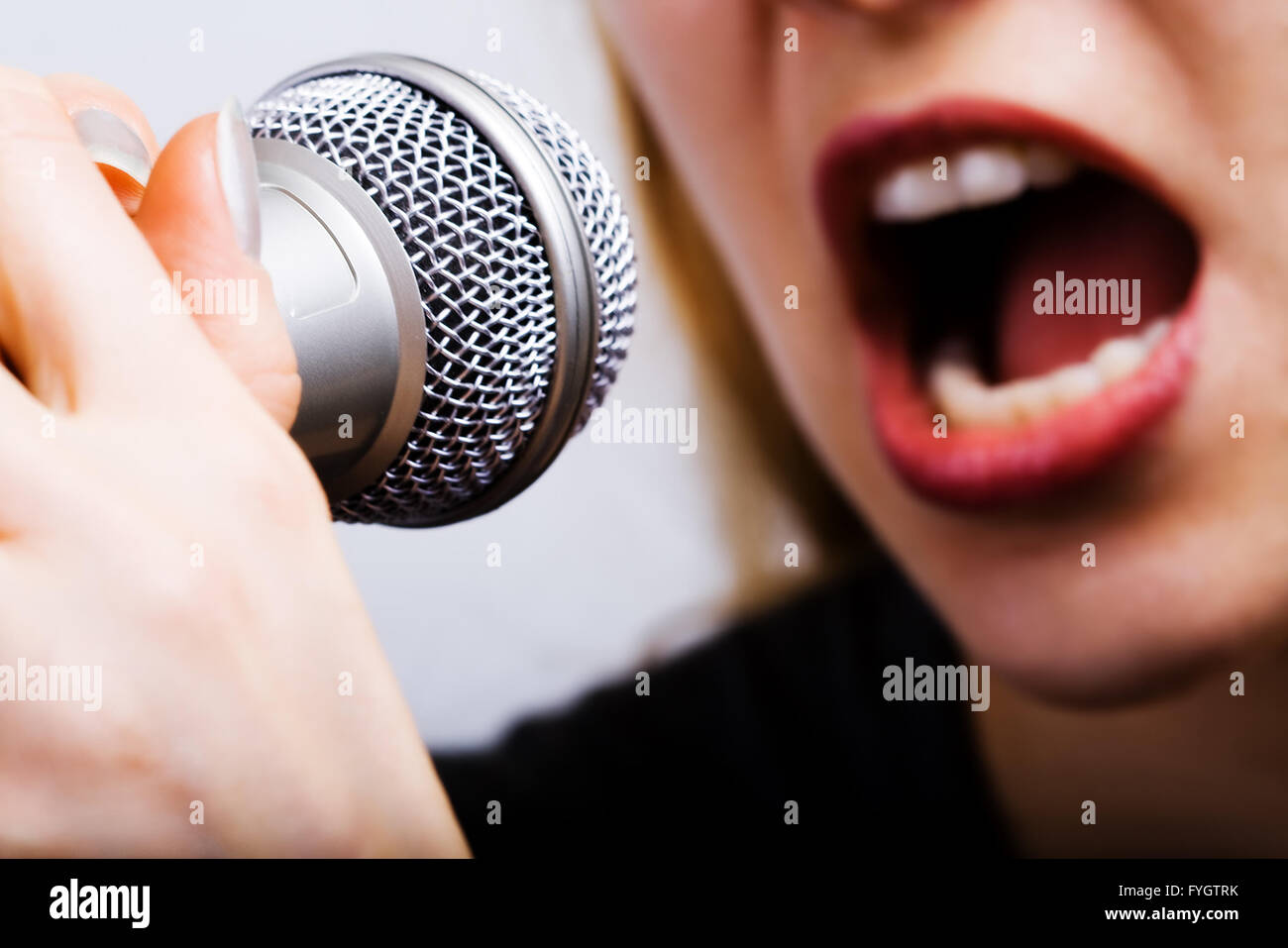 Performer Singing Into Microphone High Resolution Stock Photography and