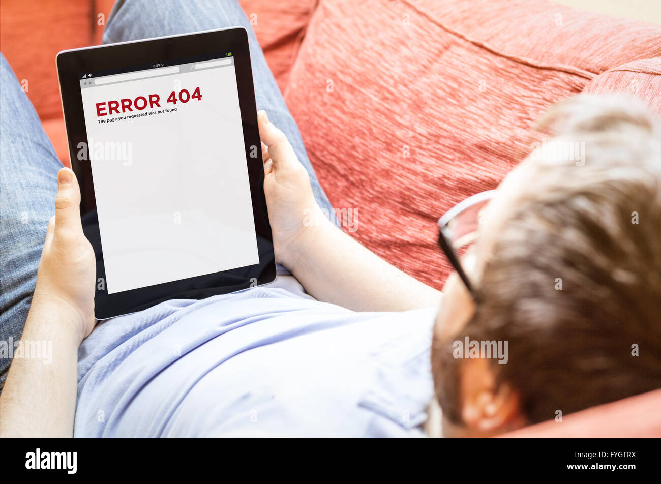 technology lifestyle connectivity concept: hipster man with error 404 on a tablet at the sofa Stock Photo