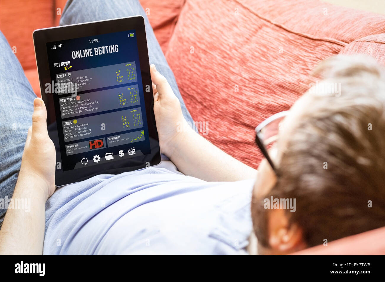 bet online concept: hipster man betting online on a tablet at the sofa Stock Photo