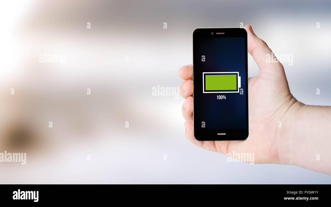 digital generated smartphone on user´s hand with full battery with sea background. All screen graphics are made up. Stock Photo