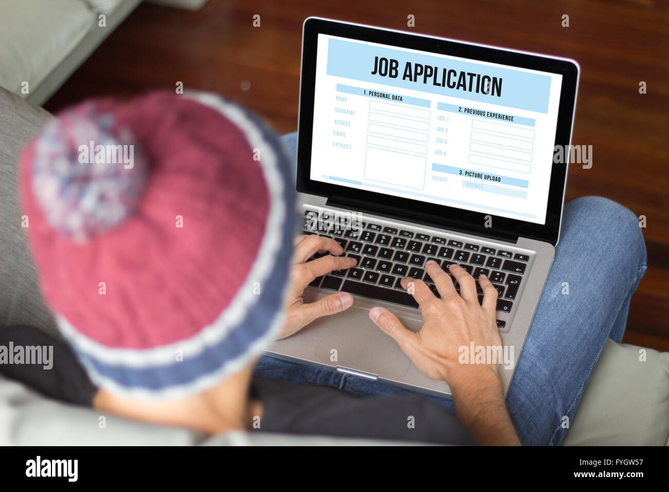 Applicant filling up online job application. All screen graphics are made up. Stock Photo