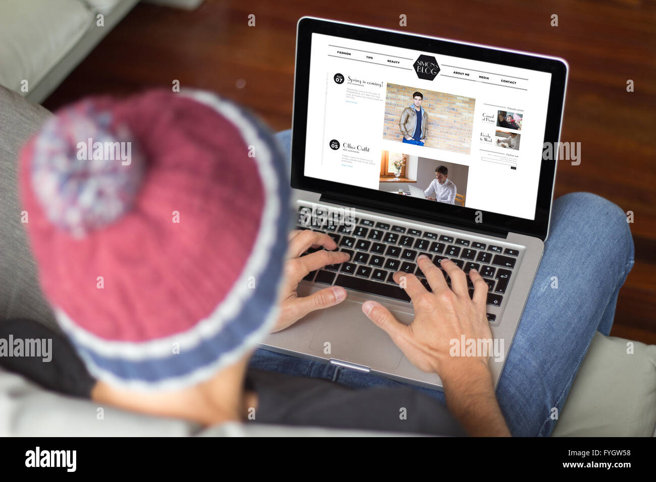 influencer surfing on a fashion male blog. All screen graphics are made up. Stock Photo