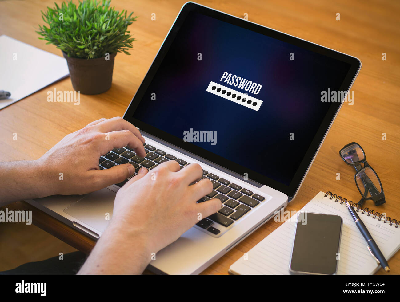 Businessman at work. Close-up top view of man working on laptop password. All screen graphics are made up. Stock Photo