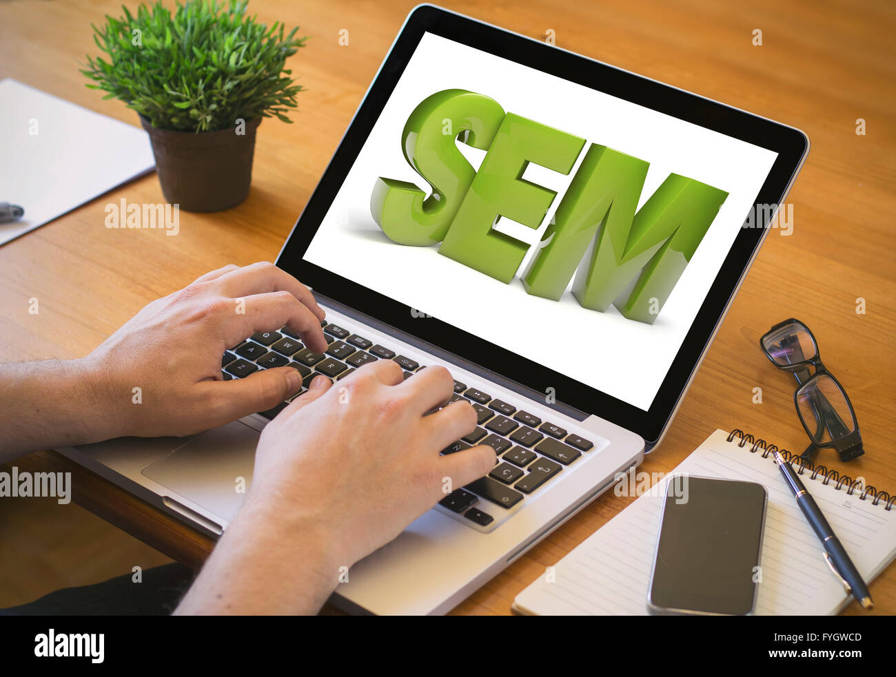 sem concept. Close-up top view of man working on laptop. all screen graphics are made up. Stock Photo
