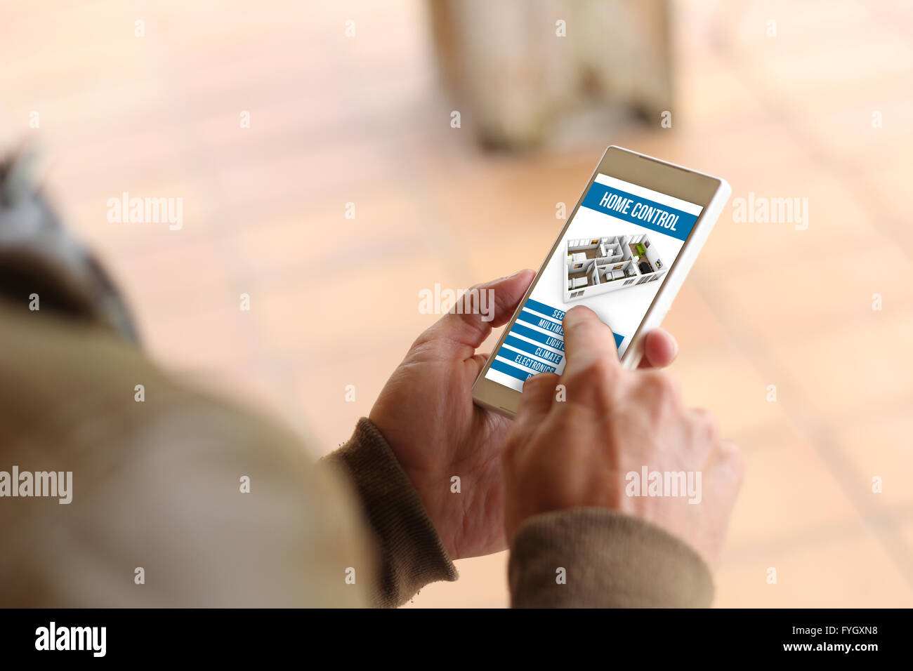 man touching the screen of his smartphone showing home automation app. All screen graphics are made up. Stock Photo