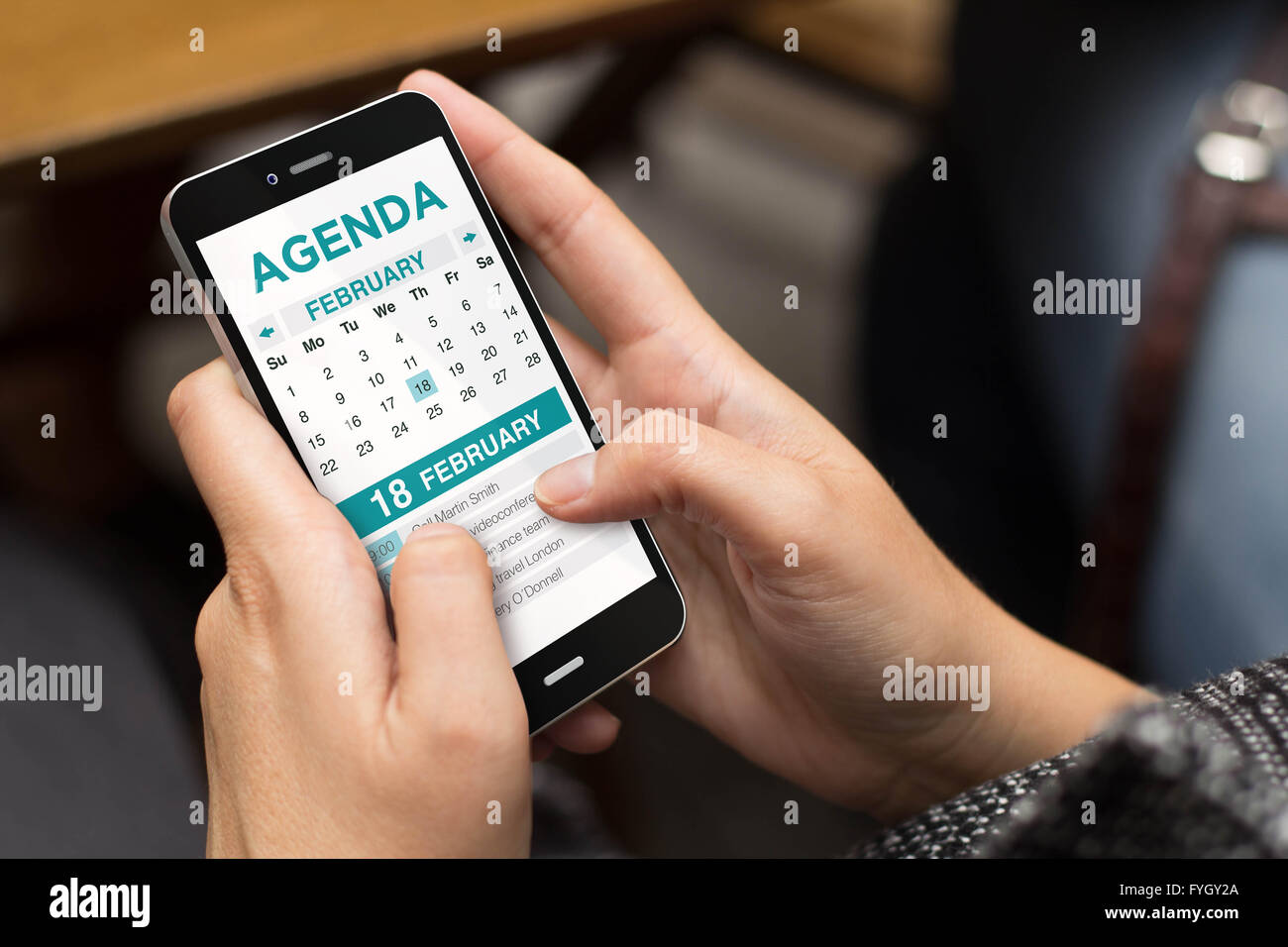 organization concept: girl using a digital generated phone with agenda on the screen. All screen graphics are made up. Stock Photo