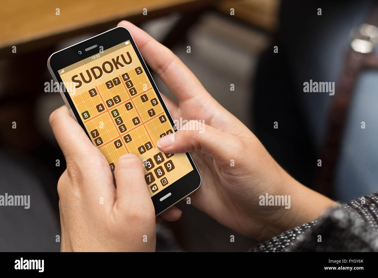 woman playing sudoku game at smartphone Stock Photo