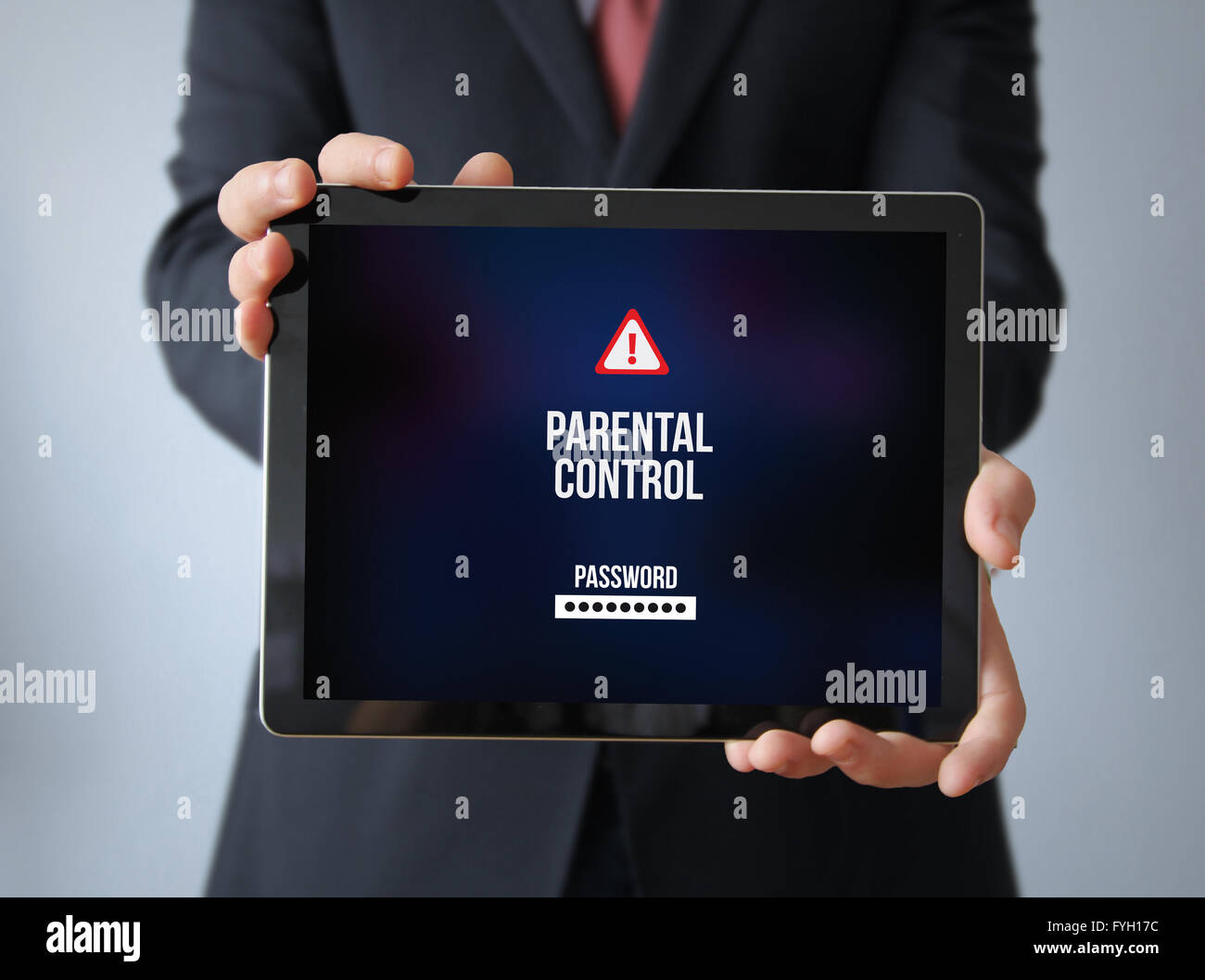 child security concept: businessman with parental control on a tablet. Screen graphics are made up. Stock Photo