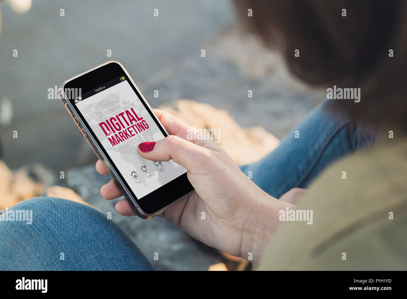 woman holding a smartphone with digital marketing on screen. All screen graphics are made up. Stock Photo