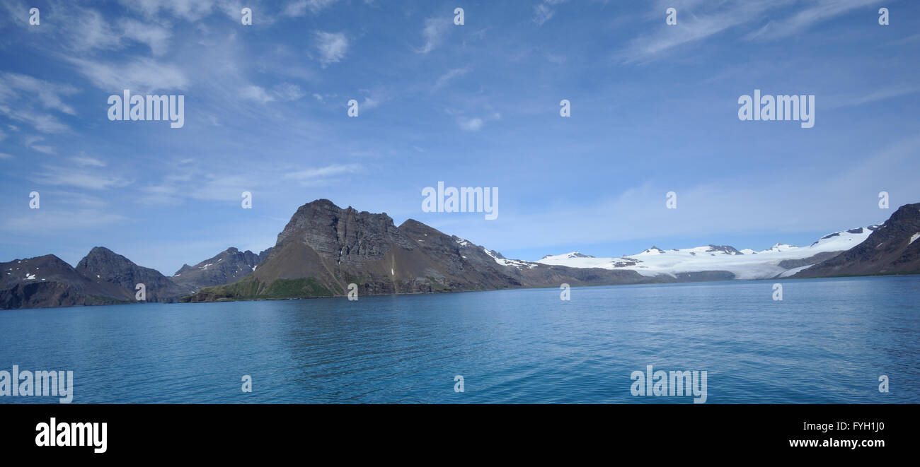 Blue sky and blue sea and the mountains and glaciers behind Bay of Isles. Bay of isles,  South Georgia. Stock Photo