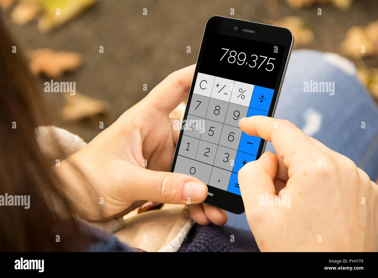 technologie and finances concept: woman holding a 3d generated smartphone with calculator app on the screen. Graphics on screen Stock Photo