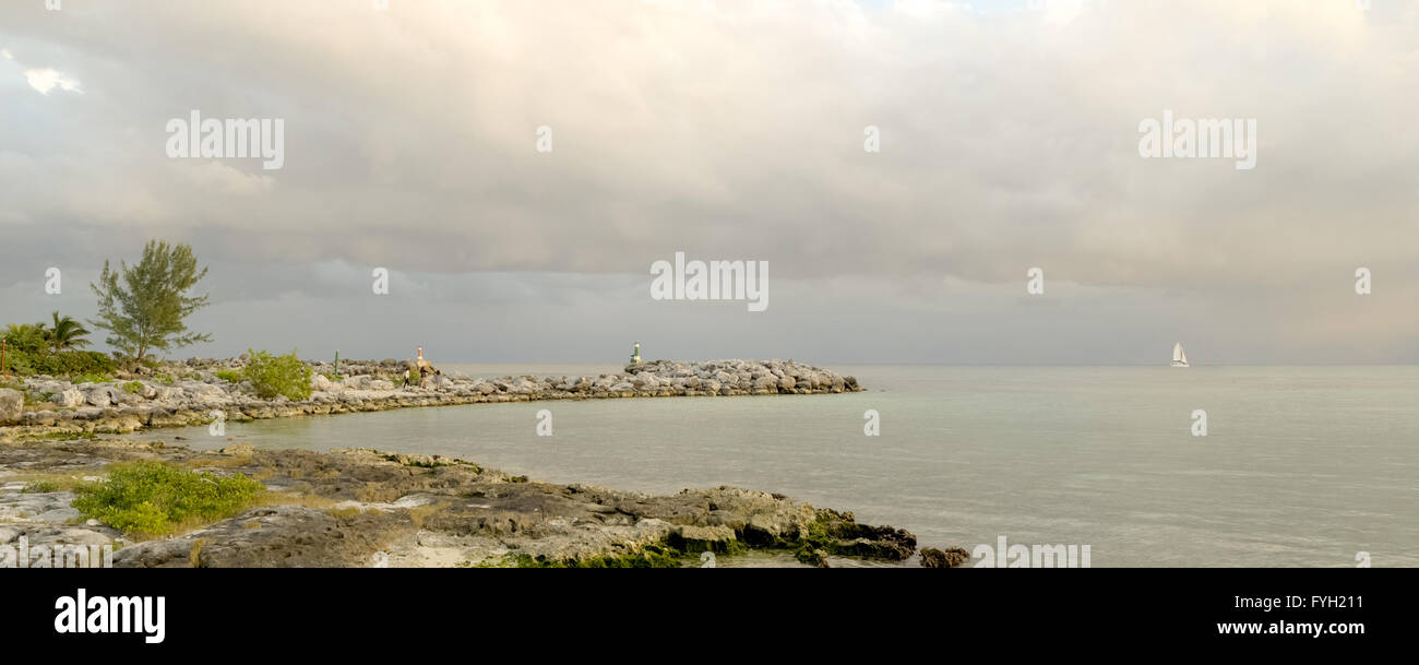 Panoramic view of empty beach landscape with clouds in the sky and rocky sea shore. Stock Photo