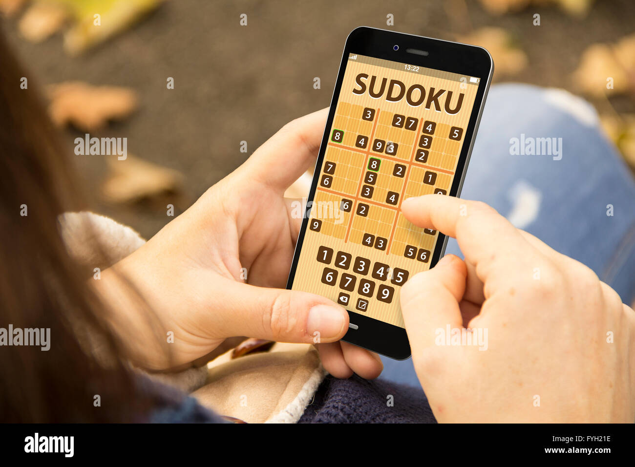 young woman with sudoku game application phone at the park Stock Photo