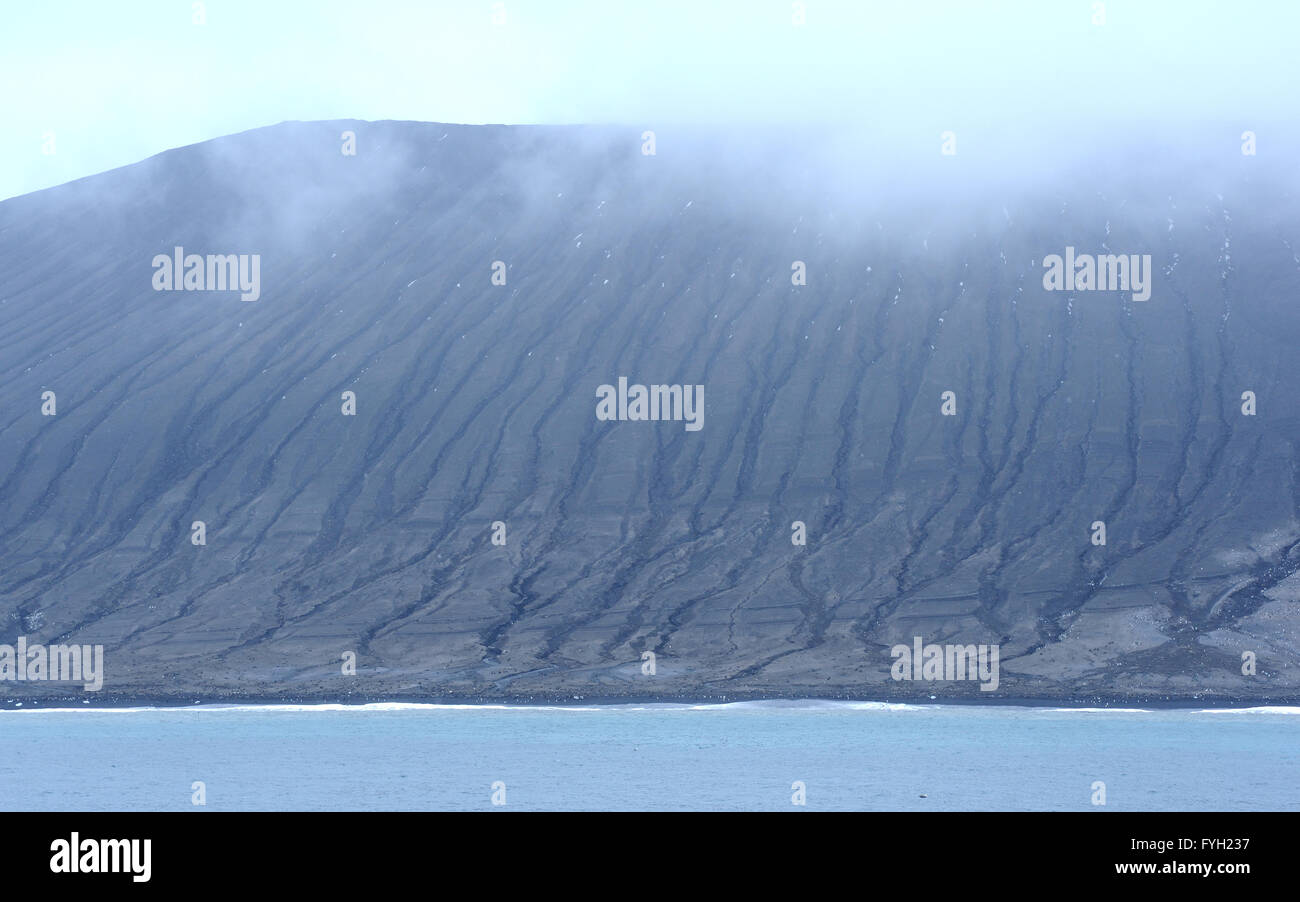 The black volcanic slopes of Saunders Island. The  slopes of black volcanic sand are heavily eroded by rain and wind. Stock Photo