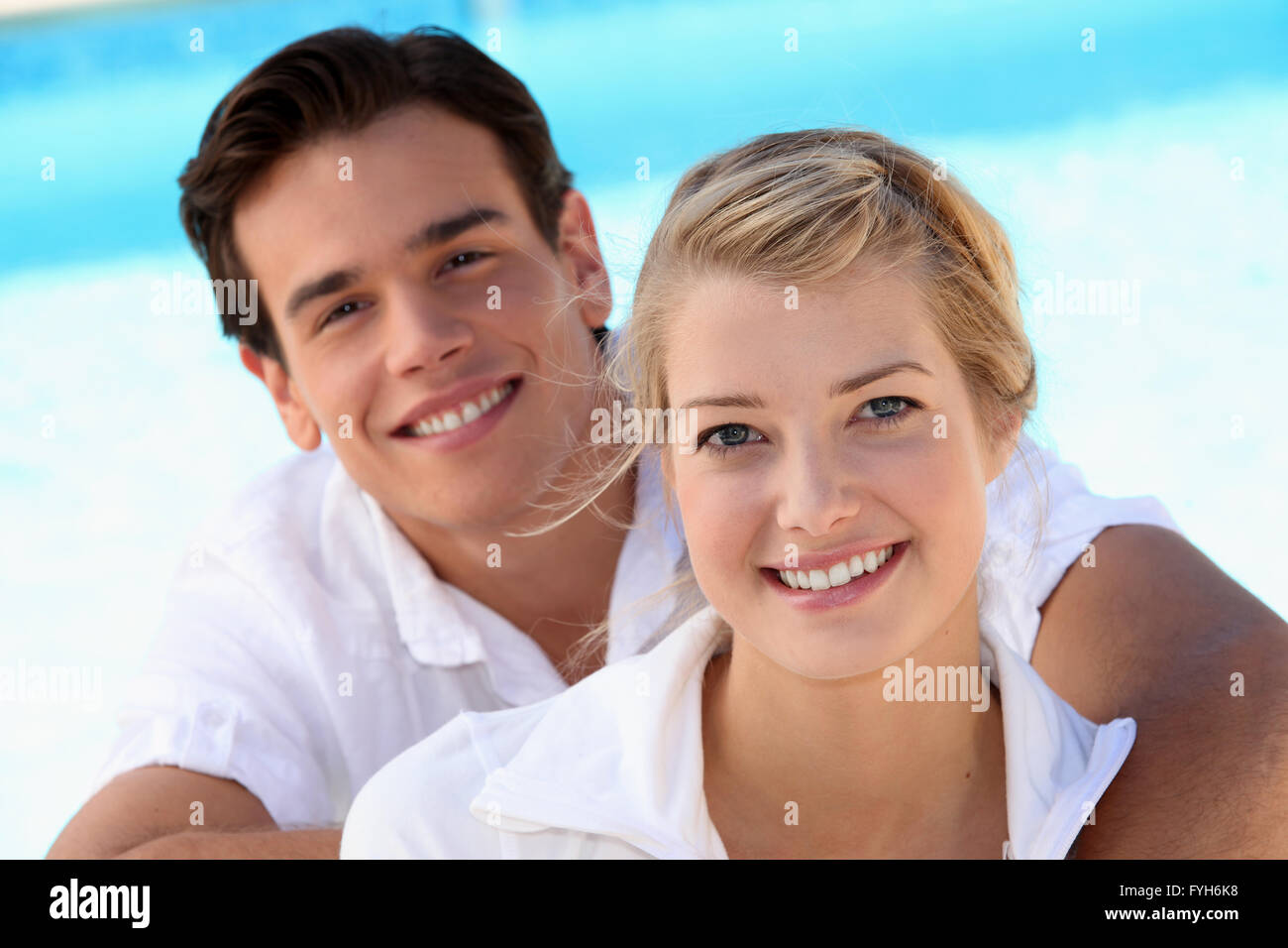 Smiling young couple with a blue sky background Stock Photo