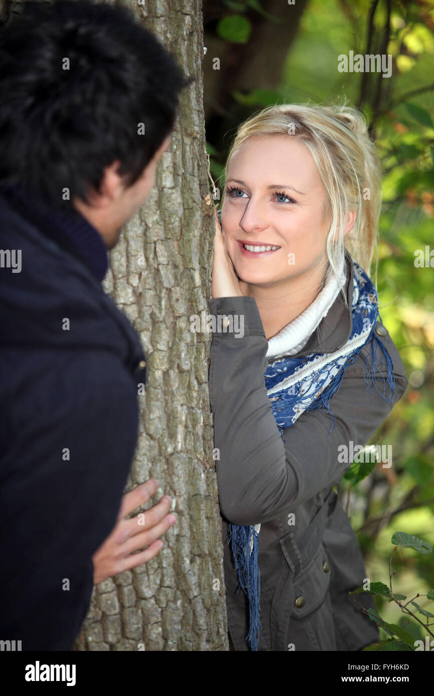 a blonde woman watching lovingly a man in the forest Stock Photo