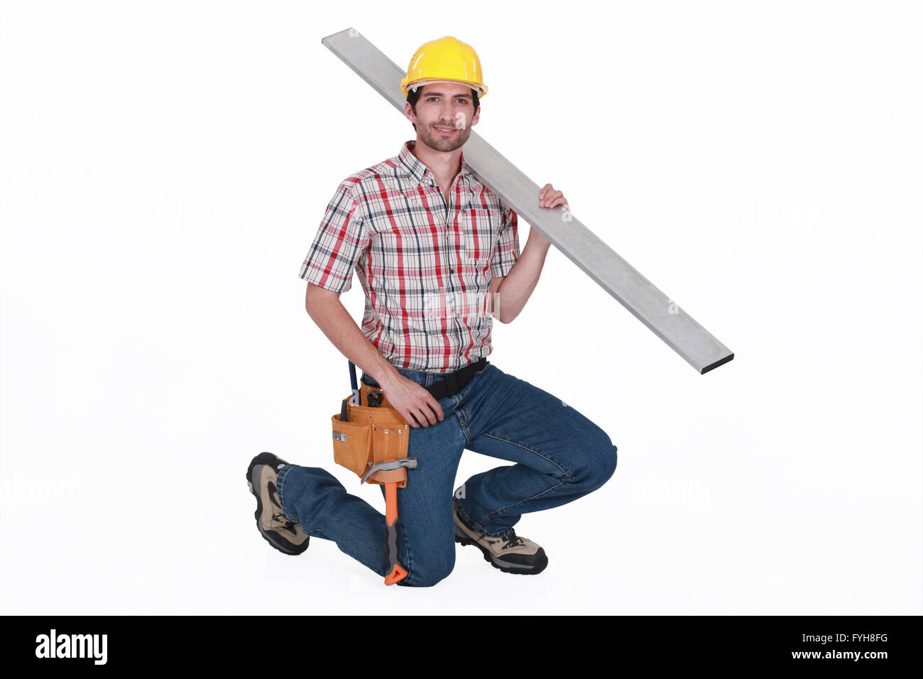 portrait of handsome carpenter against white background carrying steel post Stock Photo