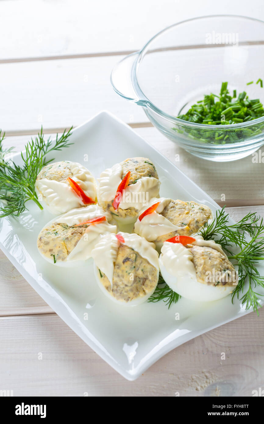 Dish with hard boiled eggs in mayonnaise parsley nad chopped chives, on