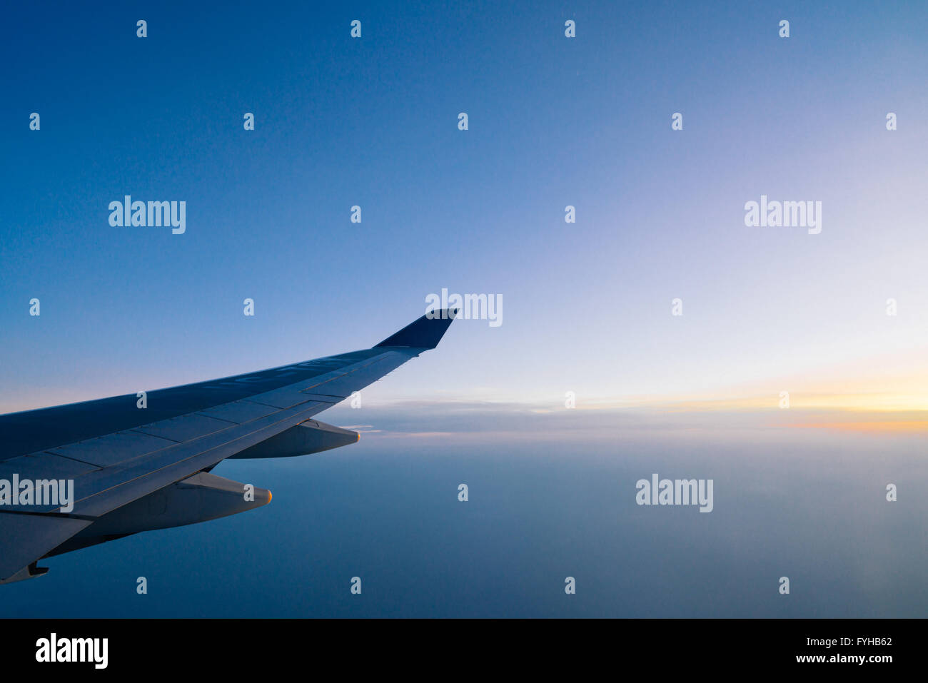 Airplane wing on the dawn sky background Stock Photo