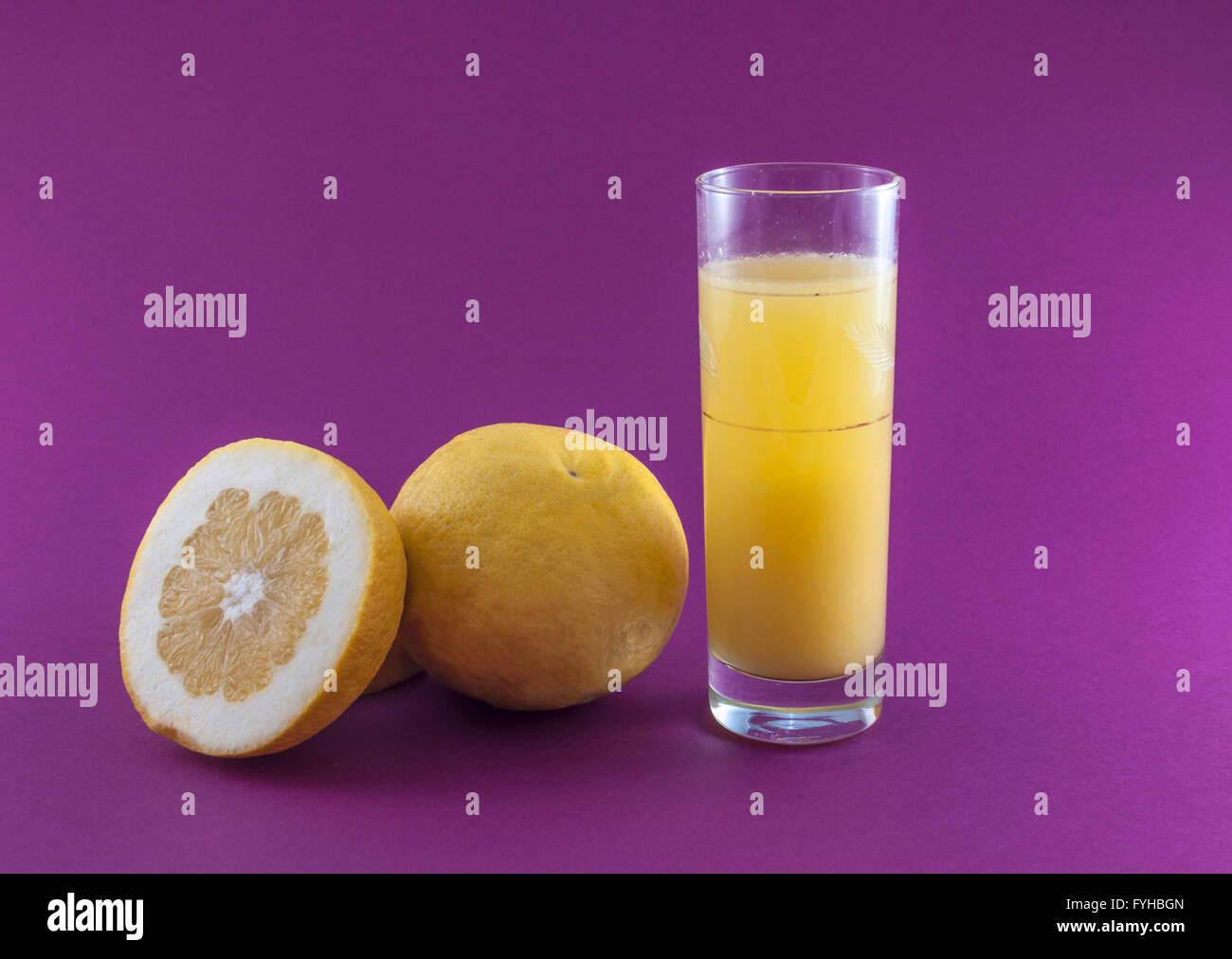 grapefruit juice and fruit on colored background Stock Photo