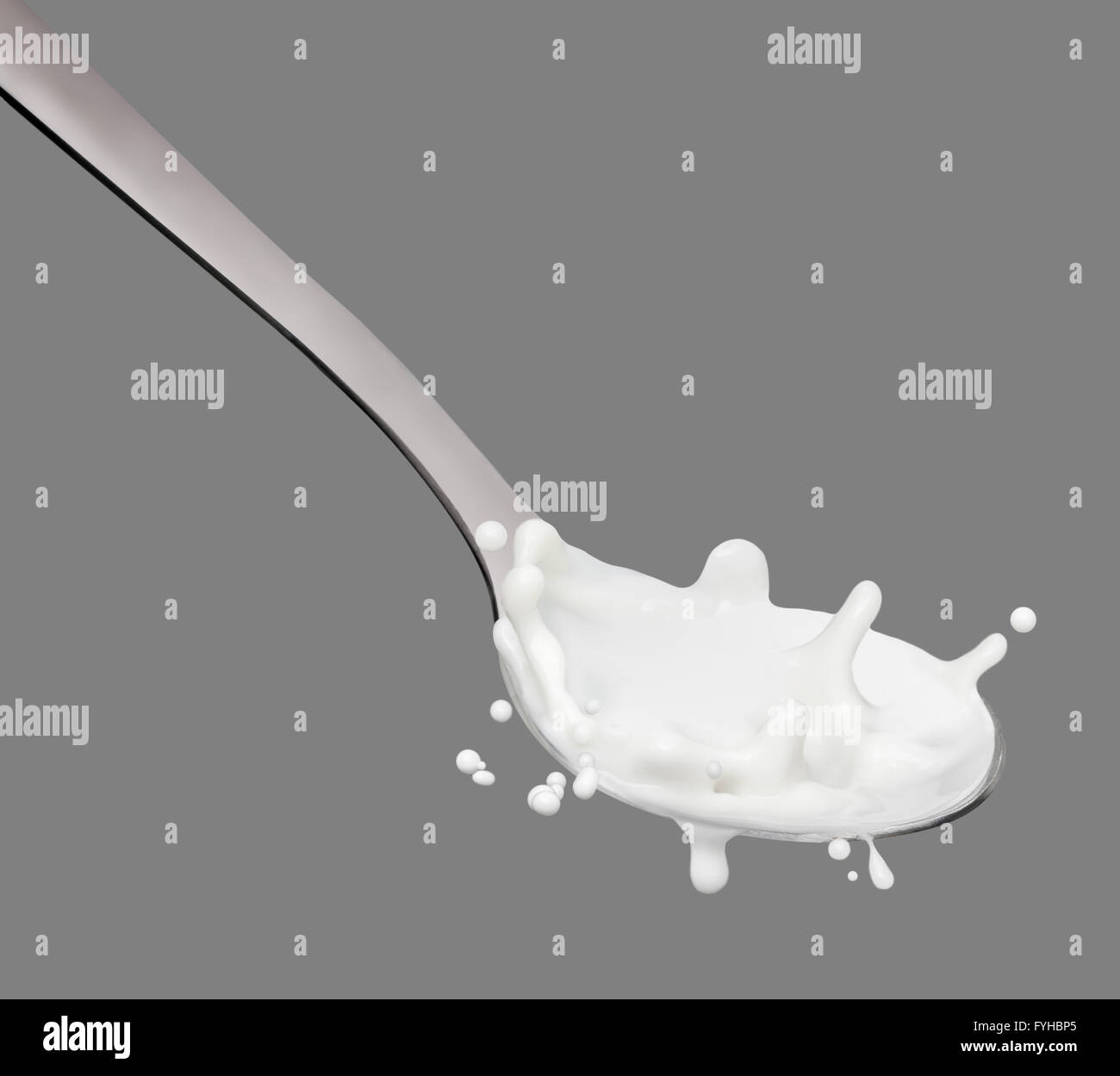 Milk splashing onto spoon Stock Photo