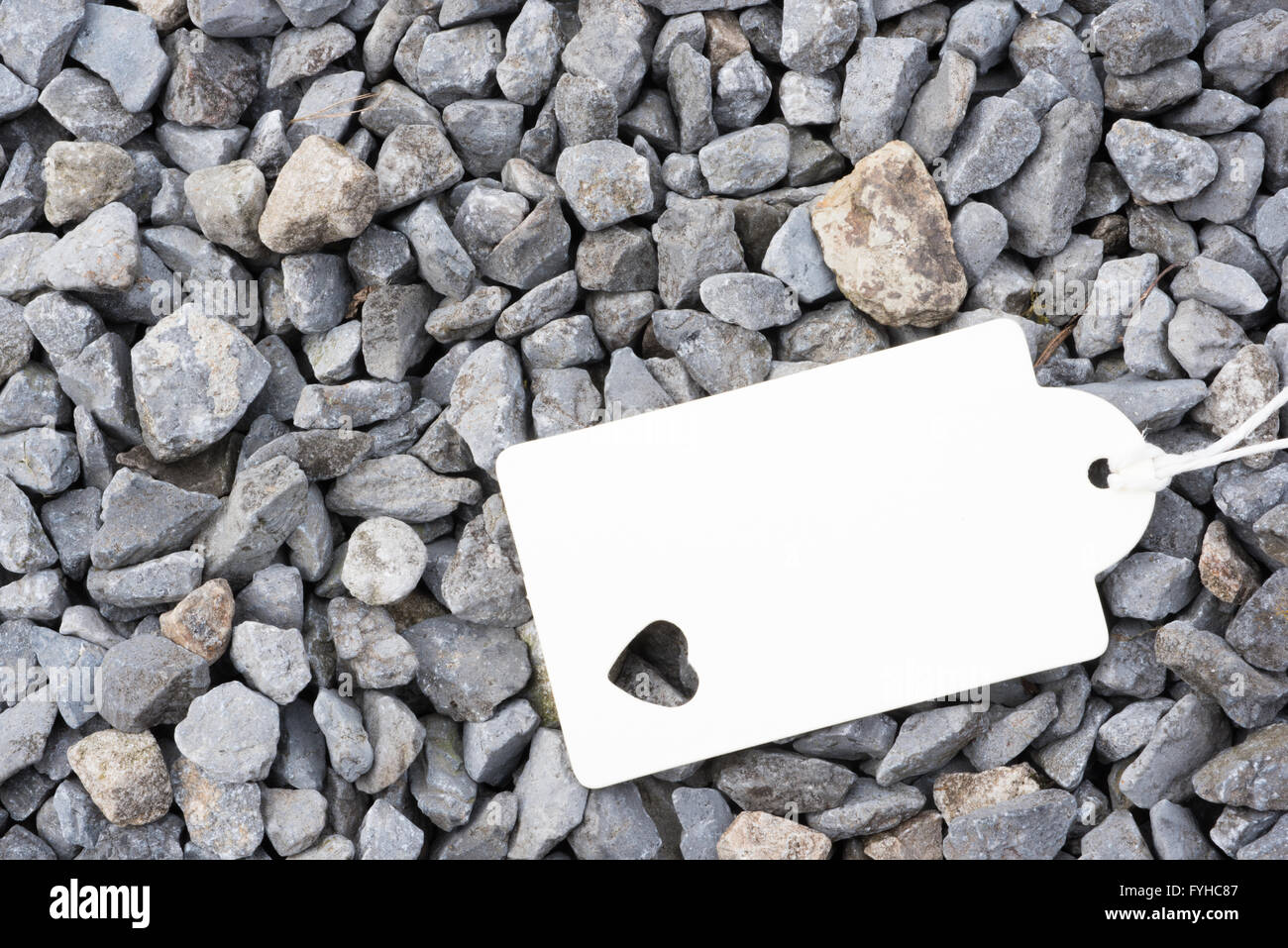 white badge with heart shape is lying on stones Stock Photo