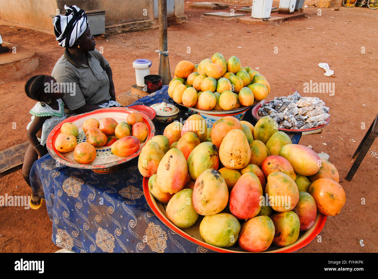 Burkina Faso, mother and child sell Mangoes at market in village Stock Photo