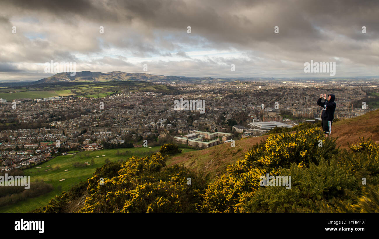 A student watches the partial eclipse from Arthur's Seat in Edinburgh, Scotland. Stock Photo