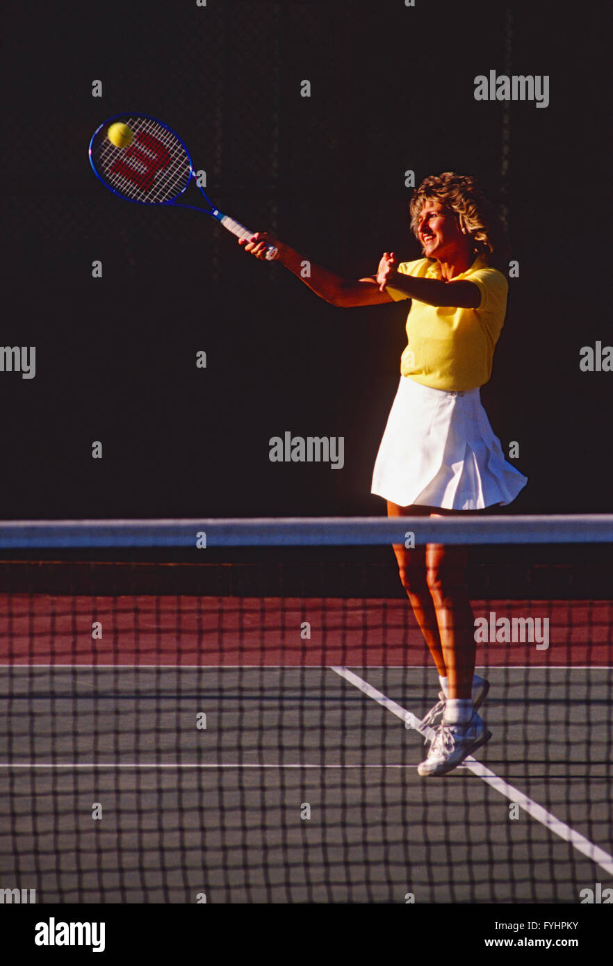 Female tennis player hitting the ball with a racket Stock Photo