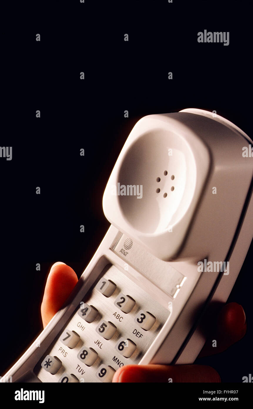 Hand on telephone receiver Stock Photo
