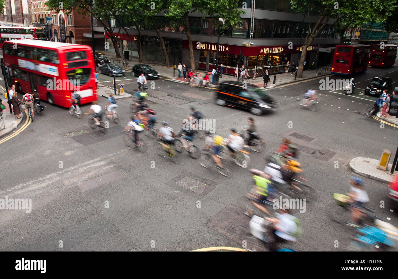 London, England - July 5, 2011: Commuter cyclists set off from a green light at a busy road junction in Central London. Stock Photo