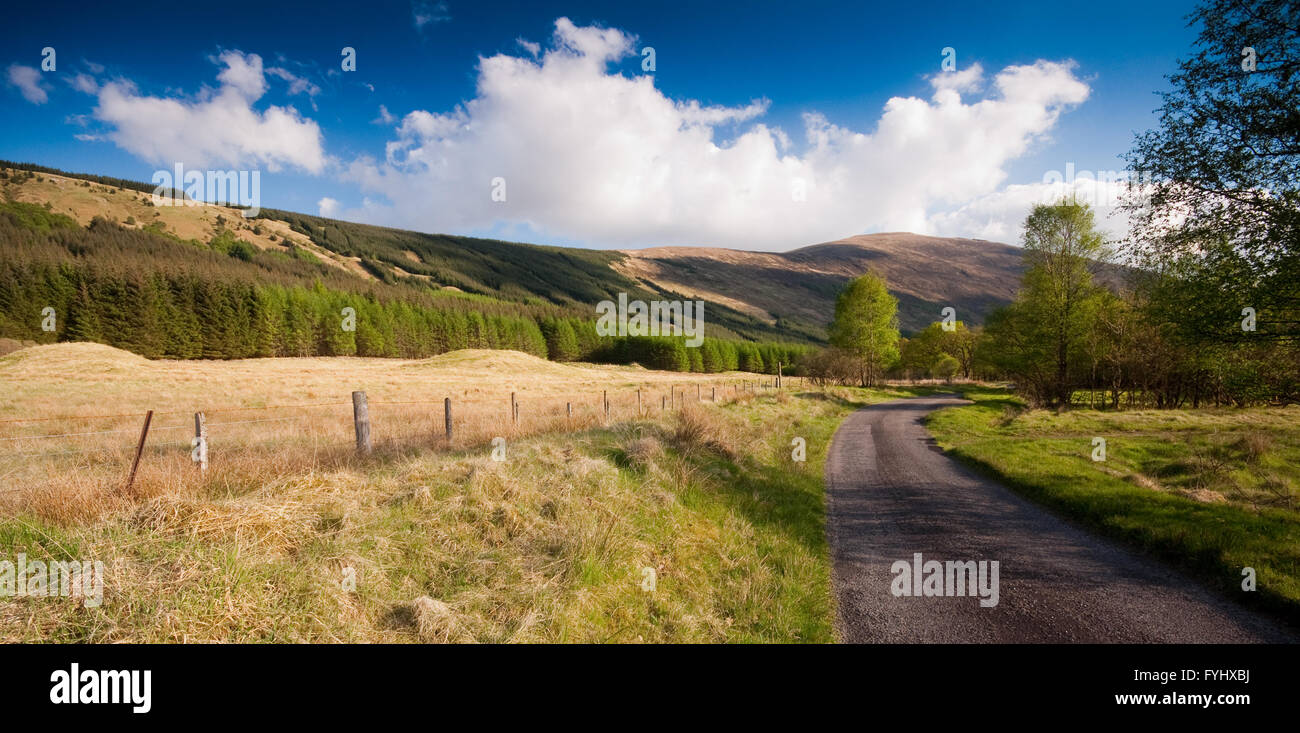 A single-track country lane meanders through remote Glen Orchy in the West Highlands of Scotland. Stock Photo