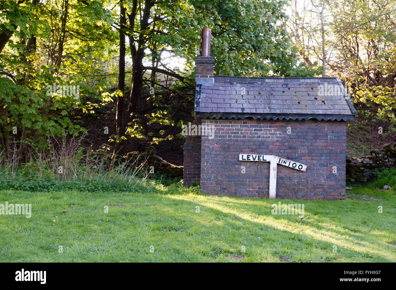 A 19th century Victorian railway trackside building and sign indicating a 1 in 100 incline, in Derbyshire, England. Stock Photo