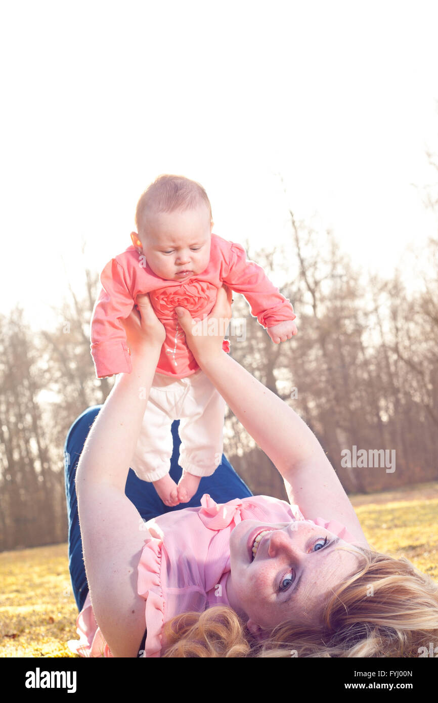 Mother is smiling when holding up her baby Stock Photo