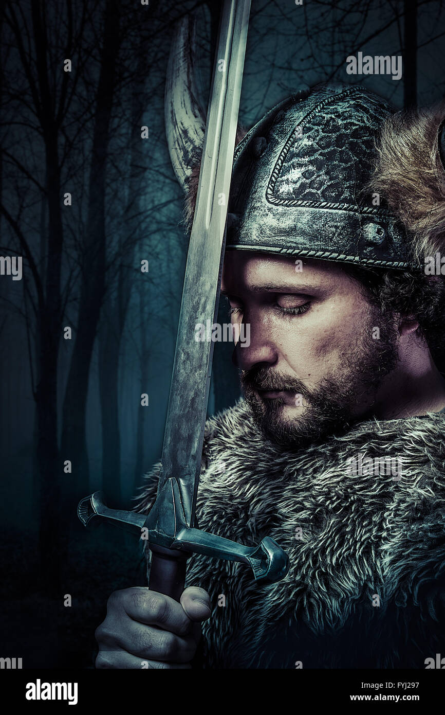 Peace, Viking warrior, male dressed in Barbarian style with sword, bearded Stock Photo