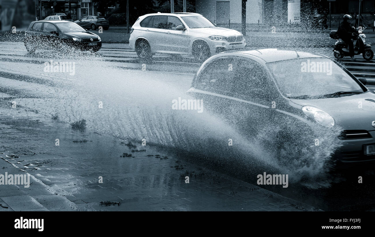 Puddle is driven through by a car Stock Photo